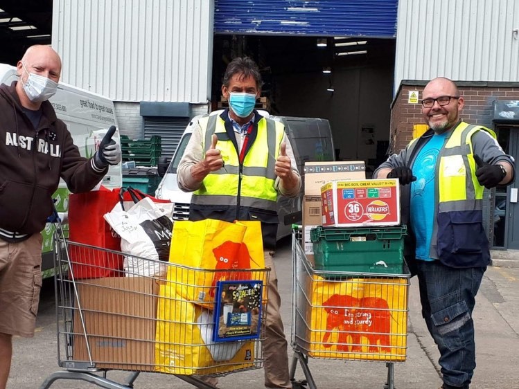 men working at the foodbank with trolleys full