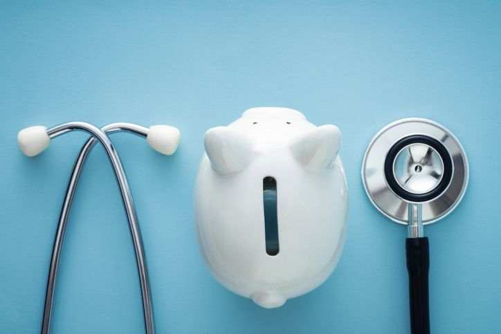 Piggy bank and stethoscope with blue background
