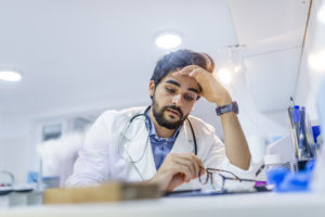 A male doctor experiencing burnout at work